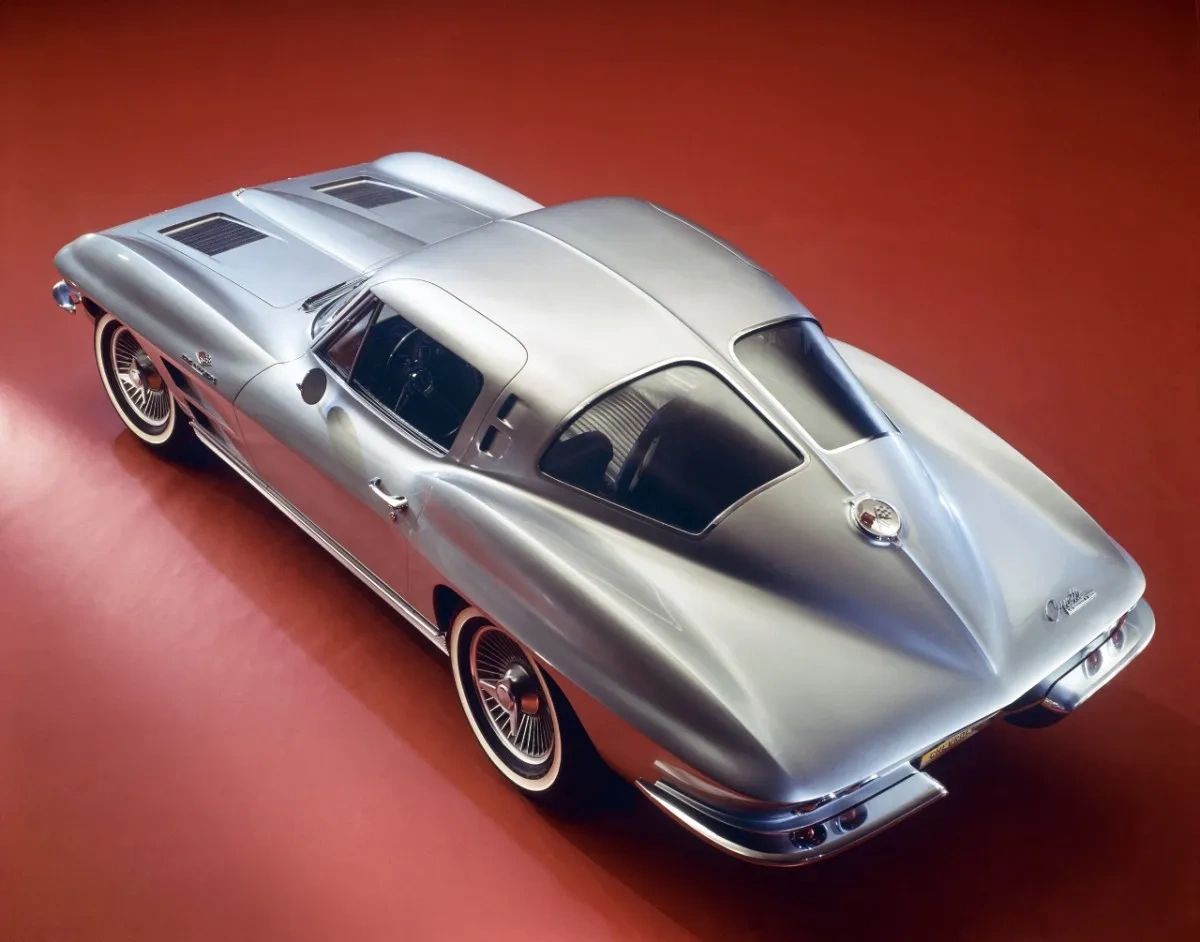 This image shows an early press release photograph of the 1963 Chevrolet Corvette Sting Ray Split-Window Coupe, captured in a studio setting to showcase its groundbreaking design. The shot emphasizes the car’s distinctive split rear window—exclusive to the 1963 model year—and the sleek, aerodynamic fastback profile that set it apart from anything else on the road. Finished in silver with knock-off wheels and whitewall tires, this official press image helped introduce the world to Bill Mitchell and Larry Shinoda’s revolutionary vision for America’s sports car. (Image courtesy of GM Media LLC.) This image shows an early press release photograph of the 1963 Chevrolet Corvette Sting Ray Split-Window Coupe, captured in a studio setting to showcase its groundbreaking design. The shot emphasizes the car’s distinctive split rear window—exclusive to the 1963 model year—and the sleek, aerodynamic fastback profile that set it apart from anything else on the road. Finished in silver with knock-off wheels and whitewall tires, this official press image helped introduce the world to Bill Mitchell and Larry Shinoda’s revolutionary vision for America’s sports car. (Image courtesy of GM Media LLC.)