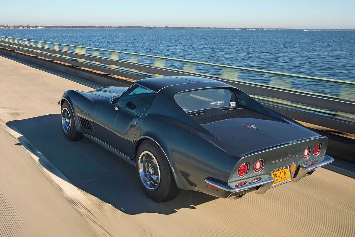 The 1970 Corvette settled into a long-legged lope on the interstate, its LT-1 singing cleanly—or the LS5 rolling on deep torque—while tall gearing kept revs relaxed. The Stingray’s tapered tail and wide track made it feel planted over expansion joints, more grand tourer than brute when you let it stretch. With the roof panels locked in and that pop-out rear window available for flow, the cabin stayed surprisingly calm as the miles disappeared.