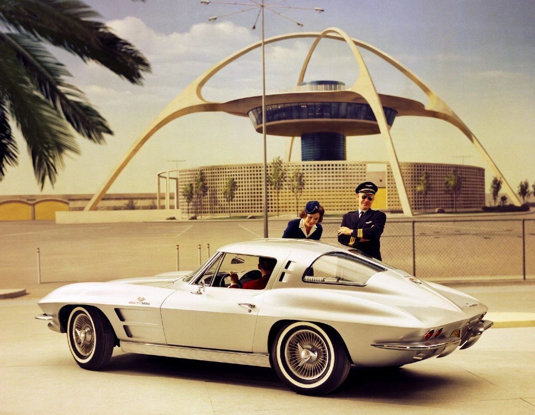 This period promotional photo captures the futuristic spirit of the 1963 Corvette Sting Ray Split-Window Coupe, posed in front of the equally space-age LAX Theme Building in Los Angeles. The sleek silver coupe, with its dramatic fastback roofline and turbine-style knock-off wheels, embodies the jet-age optimism of the early 1960s. Together, the Sting Ray and the modernist architecture symbolized America’s confidence in design, technology, and innovation at the dawn of a new era. (Image courtesy of GM Media LLC.) This period promotional photo captures the futuristic spirit of the 1963 Corvette Sting Ray Split-Window Coupe, posed in front of the equally space-age LAX Theme Building in Los Angeles. The sleek silver coupe, with its dramatic fastback roofline and turbine-style knock-off wheels, embodies the jet-age optimism of the early 1960s. Together, the Sting Ray and the modernist architecture symbolized America’s confidence in design, technology, and innovation at the dawn of a new era. (Image courtesy of GM Media LLC.)