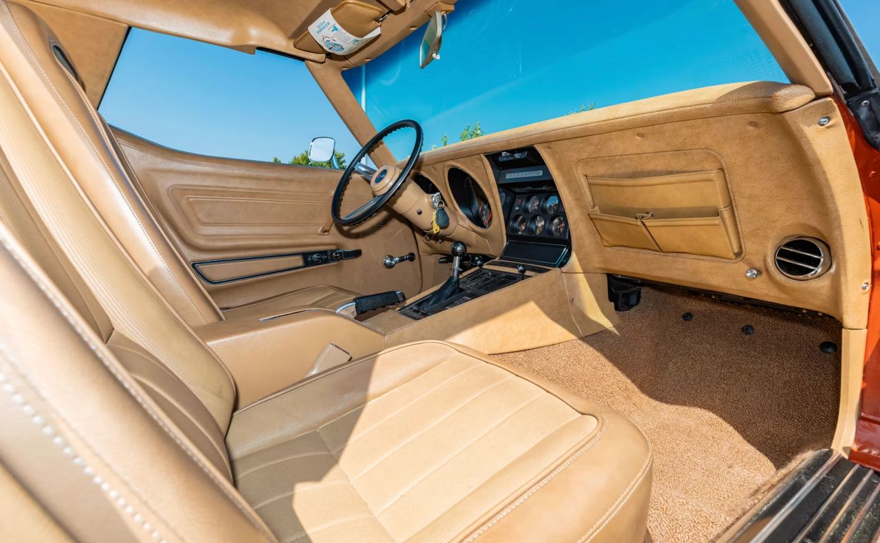 Purpose-built inside: the tan cockpit put the auxiliary gauges and four-speed shifter front and center, while the console stack was conspicuously bare—no radio head unit and no air-conditioning controls, just the essentials. That radio-delete, non-A/C layout matched the ZR1’s philosophy of cutting weight and complexity in favor of durability. Trim looked upscale, but the cabin itself felt all business. (Image courtedy of Mecum Auctions)