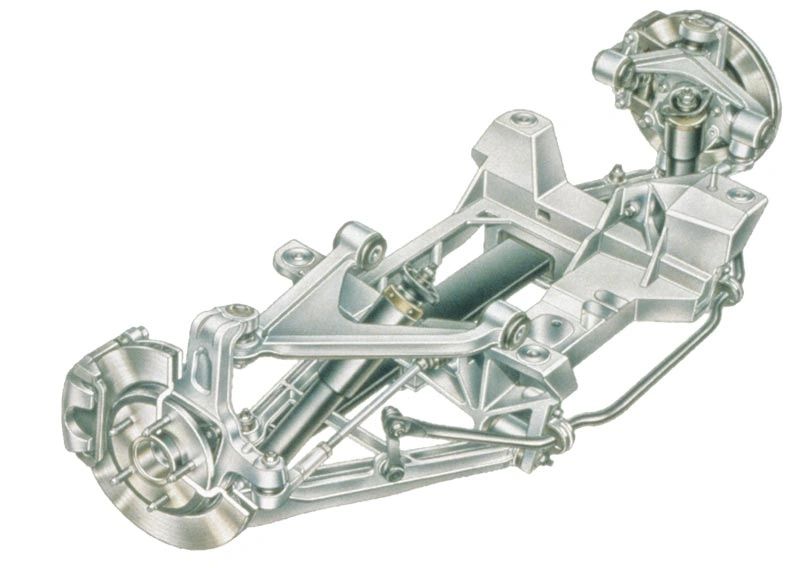 The image shows the C5 Corvette’s rear suspension module—a double-wishbone (short/long arm) layout mounted to a rigid cradle. It pairs forged-aluminum control arms and knuckles with a composite transverse leaf spring, monotube shocks, a toe link, and a hollow anti-roll bar to slash unsprung mass. This compact, lightweight package worked around the rear transaxle and is a big reason the C5 felt planted and modern compared with the C4.