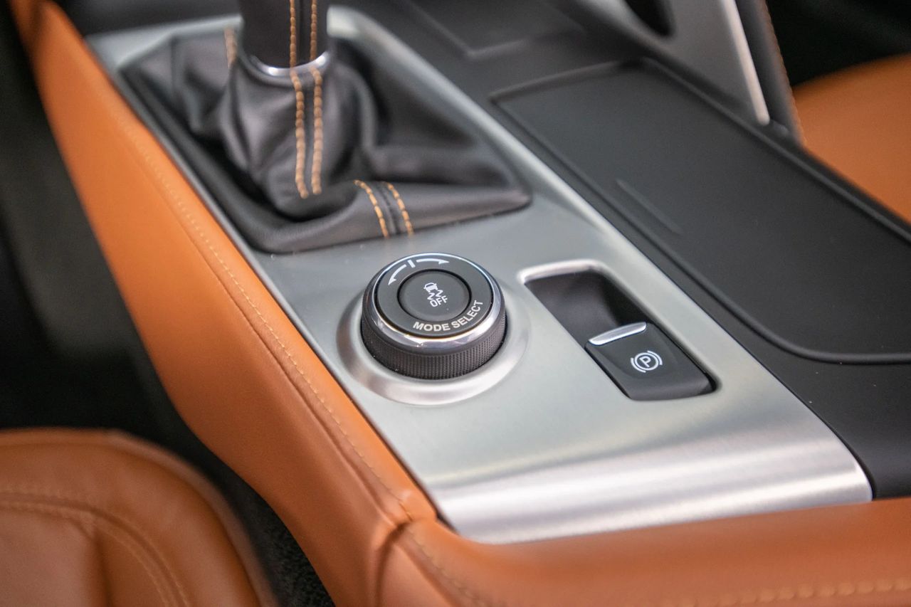 The C7’s Mode Select knob puts the car’s personality at your fingertips—spin from Tour to Sport to Track (plus Eco/Weather) and it retunes throttle, steering, stability control, and—when equipped—Magnetic Ride and the NPP exhaust in one click. The knurled rotary and stitched-leather surround feel properly mechanical, while the electronic parking brake cleans up the console and saves weight. It’s everyday civility and pit-lane focus living side-by-side. (Image courtesy of RK Motors)