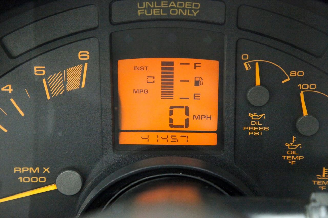 The 1990 Corvette introduced a redesigned instrument cluster that blended digital and analog readouts for the first time. At the center sat a bright orange LCD display providing speed, fuel economy, and trip information, flanked by traditional analog gauges for tachometer, oil pressure, and temperature. This hybrid layout offered the futuristic feel of the C4’s earlier all-digital dash while restoring the tactile clarity many enthusiasts had missed, making it both more functional and more in tune with Corvette’s performance image.