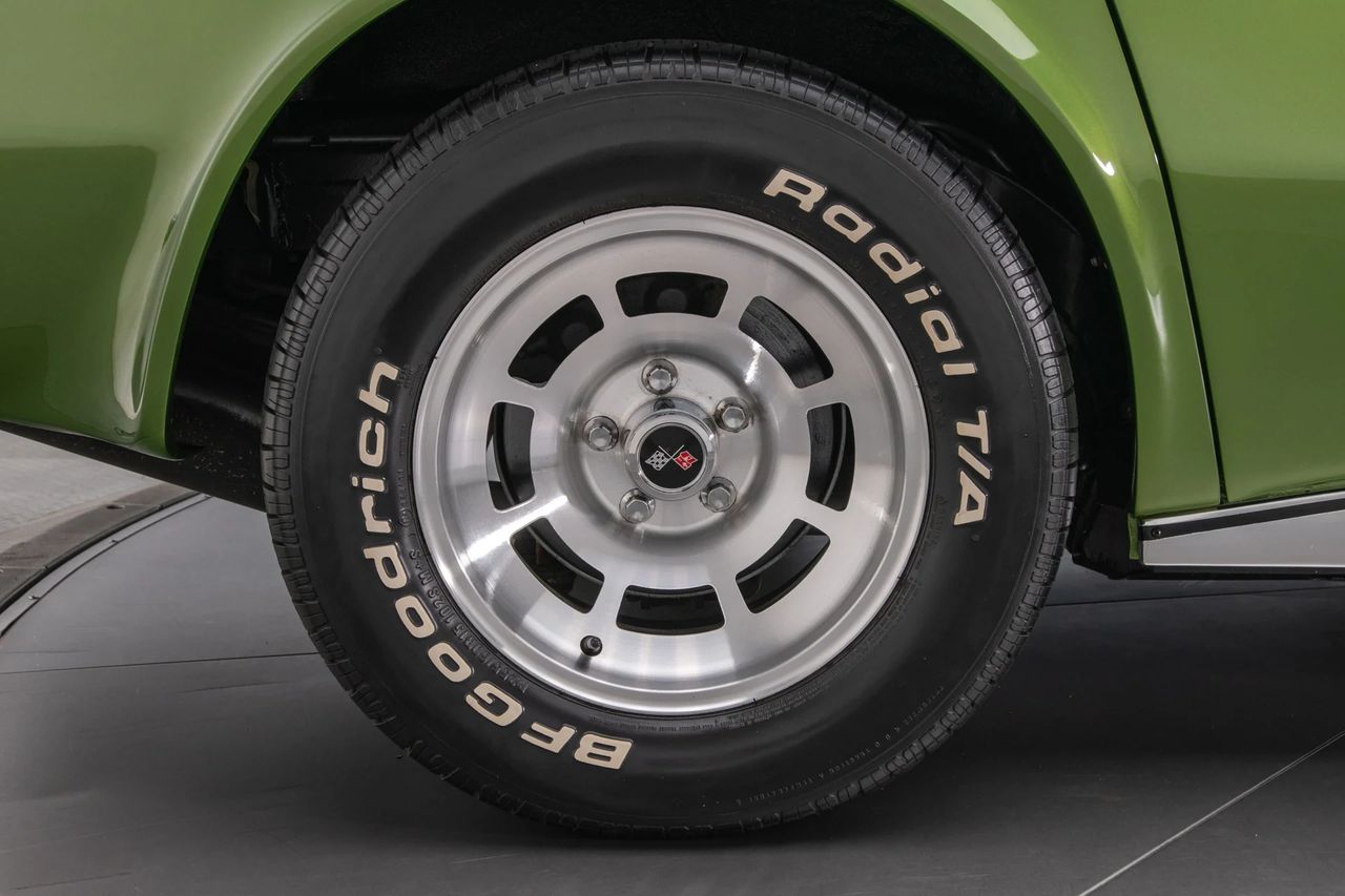 The 1973 Corvette YJ8 wheel option marked Chevrolet’s first serious push into lightweight aluminum rolling stock for America’s favorite fiberglass sports car. These cast aluminum wheels—distinguished by their symmetrical 8-slot turbine-style windows and small tri-bar center cap—shaved precious unsprung mass at a moment when Corvette engineering was fighting weight everywhere it could. Not only did they signal a break from stamped-steel wheel norms, they previewed an industry transition toward aluminum wheels as de facto performance equipment in the decades to follow. In 1973, they weren’t the popular choice—networks of purists still clung to road feel over material innovation—but they were the right choice for anyone who understood racing math: less weight at the wheel meant more wheel doing the driving. (Image: RK Motors)