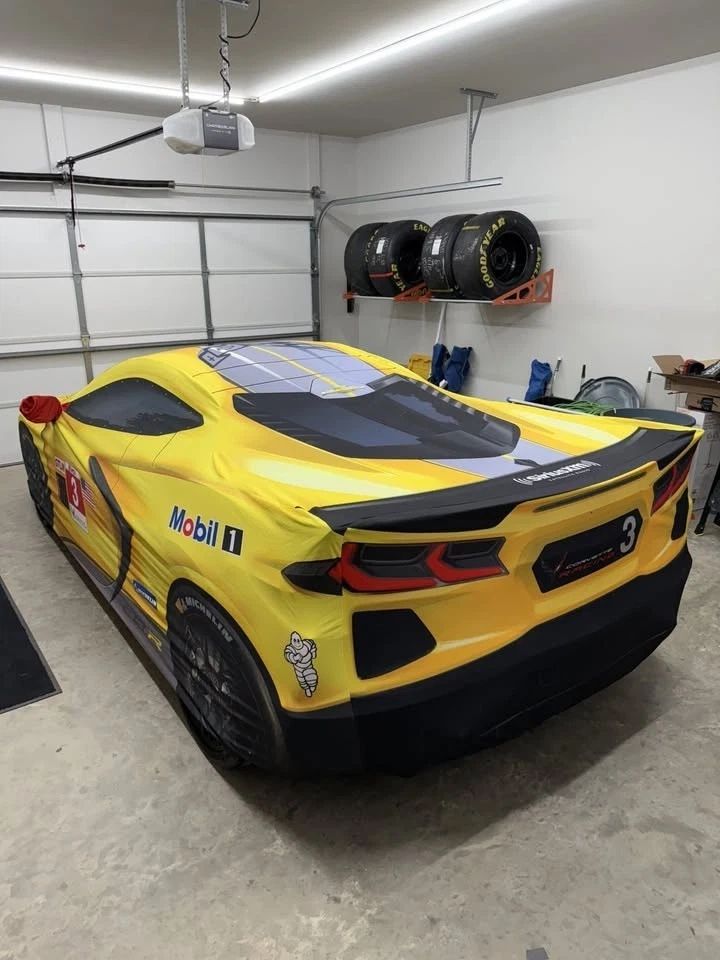 This photo captures one of the coolest “ownership perks” of the 2022 Corvette Stingray IMSA GTLM Championship Edition: the custom-fitted indoor car cover printed to mimic the look of the No. 3 Corvette C8.R race car, complete with the bold yellow/black livery cues and sponsor-style graphics. Draped over the car in a home garage, it turns a parked Stingray into a full-on Corvette Racing display piece—exactly the kind of detail that made the Championship Edition feel like a true commemorative model, not just a package of parts. (source: EBay)