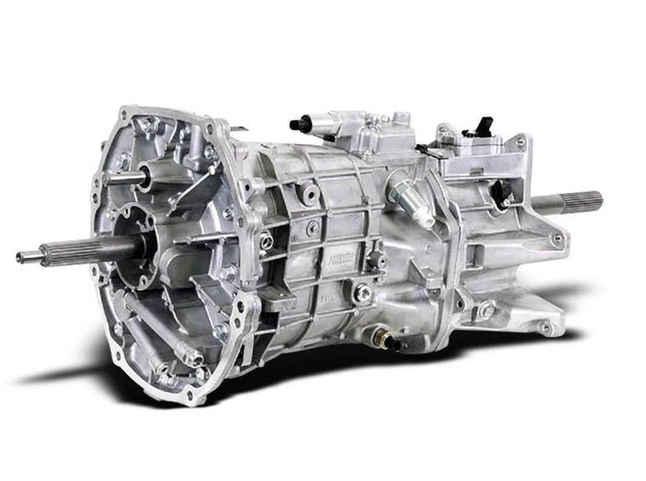 Pictured is the Borg-Warner (later Tremec) T-56 six-speed used in the 1997 Corvette. In the C5 it was packaged as a rear transaxle and linked to the LS1 by a rigid torque tube, improving weight balance and quieting NVH. The T-56’s double overdrive allowed relaxed highway rpm, and its CAGS “skip-shift” could route 1st-to-4th under light throttle for fuel-economy targets. Its robust aluminum case and heavy-duty synchronizers comfortably handled the LS1’s 345 hp/350 lb-ft while delivering the crisp shift feel that helped define the new Corvette. (Image courtesy of GM Media LLC)