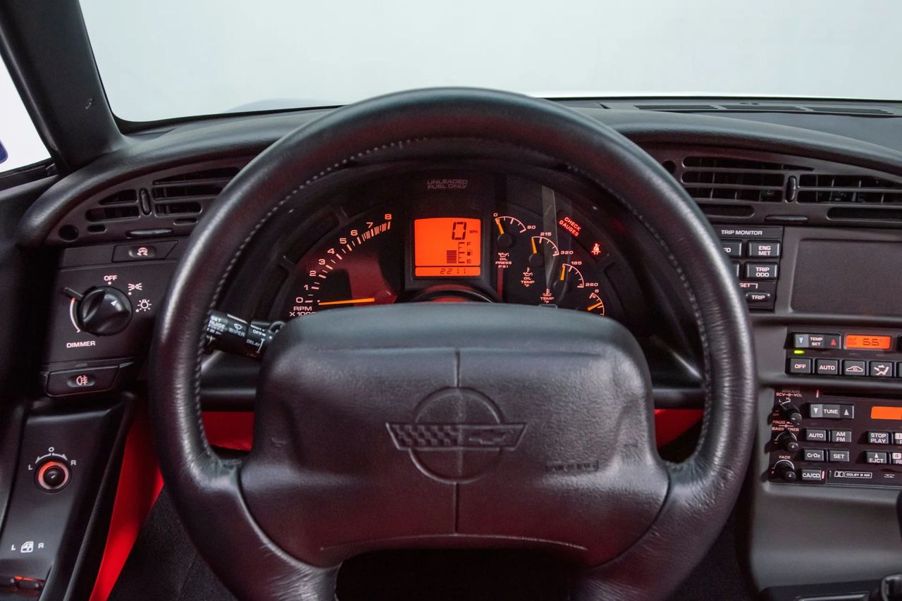 The ’96 C4’s cockpit was a rolling crime lab—the kind of “forensics” that tells you exactly what the car is doing and why. A crisp digital speed readout sits in the center while the arced tach and full analog auxiliaries ring it with oil temp/pressure, volts, and coolant temp—real numbers, not guesses. To the right, the Trip Monitor serves up the evidence: instant and average fuel economy, range to empty, dual trip mileage, and engine metrics at the touch of a button. Automatic climate control adds its own digital precision, and 1996’s OBD-II hardware backs it all with standardized diagnostics. Put together, the late C4 dash doesn’t just inform—it testifies. (Image courtesy of RK Motors)