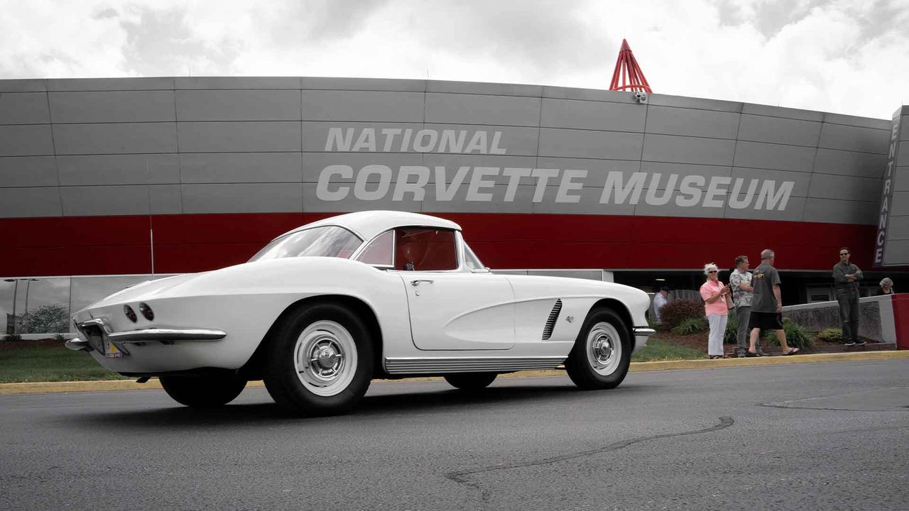 On Labor Day weekend in 1994, the National Corvette Museum opened its doors in Bowling Green, Kentucky—right across from the Corvette Assembly Plant—welcoming a sea of Corvettes that caravanned in from across the country. The scene felt like a family reunion for America’s Sports Car: early C1s like the one pictured here lined the curb as owners, engineers, and fans celebrated four decades of Corvette history. Built through grassroots support—founding memberships, commemorative bricks, and donations—the nonprofit museum set out to preserve design, engineering, and racing heritage under one roof. Early exhibits mixed milestone production cars with rare concept and racing machines, tying the showroom to the track. The building’s distinctive red-and-silver façade and spire quickly became a Bowling Green landmark. That grand opening cemented the museum as the spiritual home of Corvette culture. (Image courtesy of the National Corvette Museum)