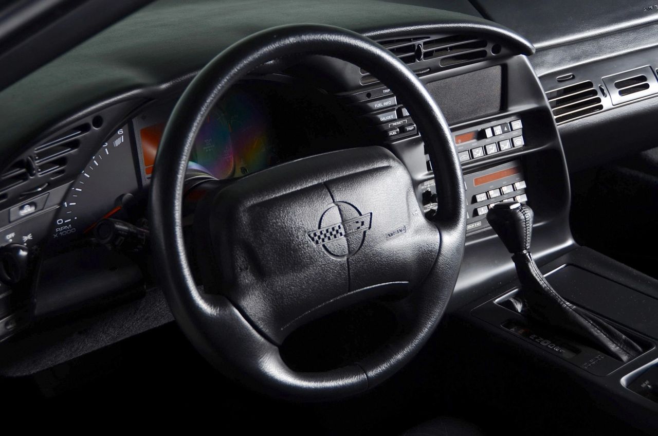 The ’95 Corvette’s 4L60-E automatic was re-tuned with a lighter, stronger converter, so it hooks the LT1’s torque quicker and shifts cleaner in real-world driving. From the driver’s seat—airbag wheel, analog/digital cluster with the new ATF temp readout, and the console-mounted selector—the cockpit feels purposeful and modern, built to crush traffic and unwind a back road without drama. (Image courtesy of motorcarclassics.com)
