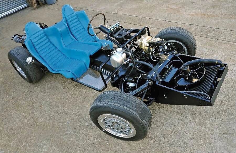 With the bodywork removed, the XP-819’s unconventional cooling strategy is on full display—most notably the front-mounted radiator tilted sharply forward over the nose. Instead of standing upright like a conventional Corvette’s, this radiator leans ahead of the front suspension, allowing air to be scooped in low at the nose and directed cleanly through the core before exiting underneath the car. That layout not only freed up space at the rear for the transversely mounted V-8, it also helped keep the nose low and the front profile sleek, critical for both aero and styling. The prominent coolant plumbing running down the center spine underscores how far Chevrolet’s engineers were willing to go to make a rear-engine Corvette workable in the mid-1960s. With the bodywork removed, the XP-819’s unconventional cooling strategy is on full display—most notably the front-mounted radiator tilted sharply forward over the nose. Instead of standing upright like a conventional Corvette’s, this radiator leans ahead of the front suspension, allowing air to be scooped in low at the nose and directed cleanly through the core before exiting underneath the car. That layout not only freed up space at the rear for the transversely mounted V-8, it also helped keep the nose low and the front profile sleek, critical for both aero and styling. The prominent coolant plumbing running down the center spine underscores how far Chevrolet’s engineers were willing to go to make a rear-engine Corvette workable in the mid-1960s.