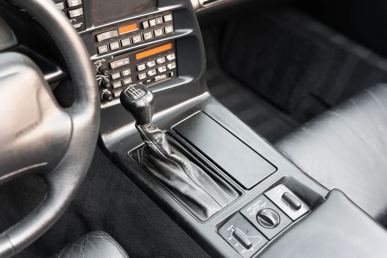 The ’95 Corvette’s ZF S6-40 six-speed feels right at home here—short, mechanical throws capped by a leather-wrapped knob and the new high-detent reverse that replaced the fiddly lockout of ’94. It’s a driver’s interface first and foremost: slide across the gate, slot the gear, and the LT1 answers with crisp torque on command. (Image courtesy of bringatrailer.com)