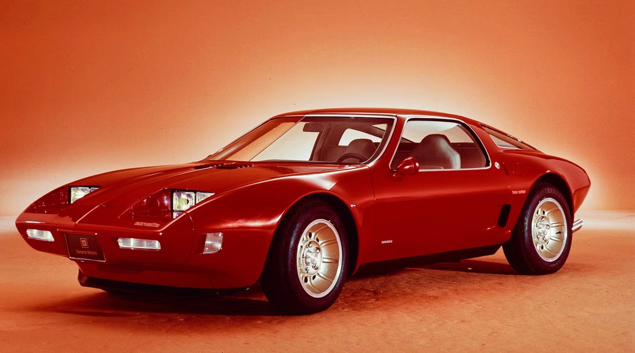 When the XP-987 GT made its public debut at the 1973 Frankfurt Motor Show, it turned heads — automotive magazines and show-goers alike praised its sleek mid-engine proportions and the audacity of packaging a rotary powerplant inside what looked like a compact European sports coupe. Reviewers gushed over its low, wide stance, hidden headlamps, and the exotic appeal of GM’s “Two-Rotor Corvette” rebirth, while the public reacted with a mixture of hope and excitement — many believed this could be the future of Corvette. The reception was enthusiastic enough that whispers spread instantly of a possible production mid-engine Corvette, powered by GM’s experimental two-rotor Wankel engine. For a shining moment, it seemed as though GM might leap ahead of the pack — until external pressures and changing conditions pulled the plug on what was already being hailed as the next great Corvette. (Image courtesy of GM Media LLC) When the XP-987 GT made its public debut at the 1973 Frankfurt Motor Show, it turned heads — automotive magazines and show-goers alike praised its sleek mid-engine proportions and the audacity of packaging a rotary powerplant inside what looked like a compact European sports coupe. Reviewers gushed over its low, wide stance, hidden headlamps, and the exotic appeal of GM’s “Two-Rotor Corvette” rebirth, while the public reacted with a mixture of hope and excitement — many believed this could be the future of Corvette. The reception was enthusiastic enough that whispers spread instantly of a possible production mid-engine Corvette, powered by GM’s experimental two-rotor Wankel engine. For a shining moment, it seemed as though GM might leap ahead of the pack — until external pressures and changing conditions pulled the plug on what was already being hailed as the next great Corvette. (Image courtesy of GM Media LLC)