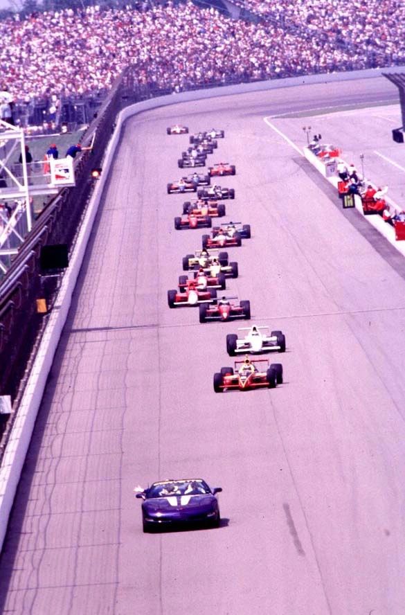 At the Brickyard in ’98, Greg Norman is sidelined by shoulder surgery, so 1963 winner Parnelli Jones takes the wheel of the Radar Blue C5 pace car. He gathers the field and draws 33 cars down the front straight, yellow wheels glinting as the grandstands rise. It reads less like a substitute and more like a statement—Indy royalty setting the tempo, Corvette credibility earned in plain sight.