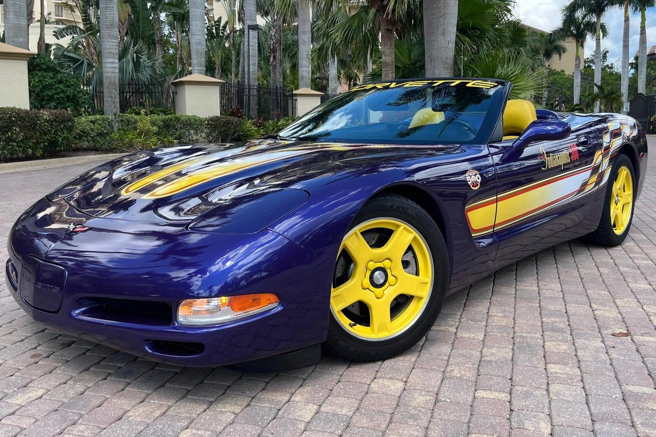 Radar Blue like wet ink, with twin yellow hood streaks that flow into the checkerboard ribbon graphics down the flanks. Color-keyed 5-spoke wheels and yellow cockpit accents carry the theme, capped by the 82nd Indy 500 fender medallion and “Indianapolis 500” door script. Pace car livery that reads loud and cohesive from every angle.