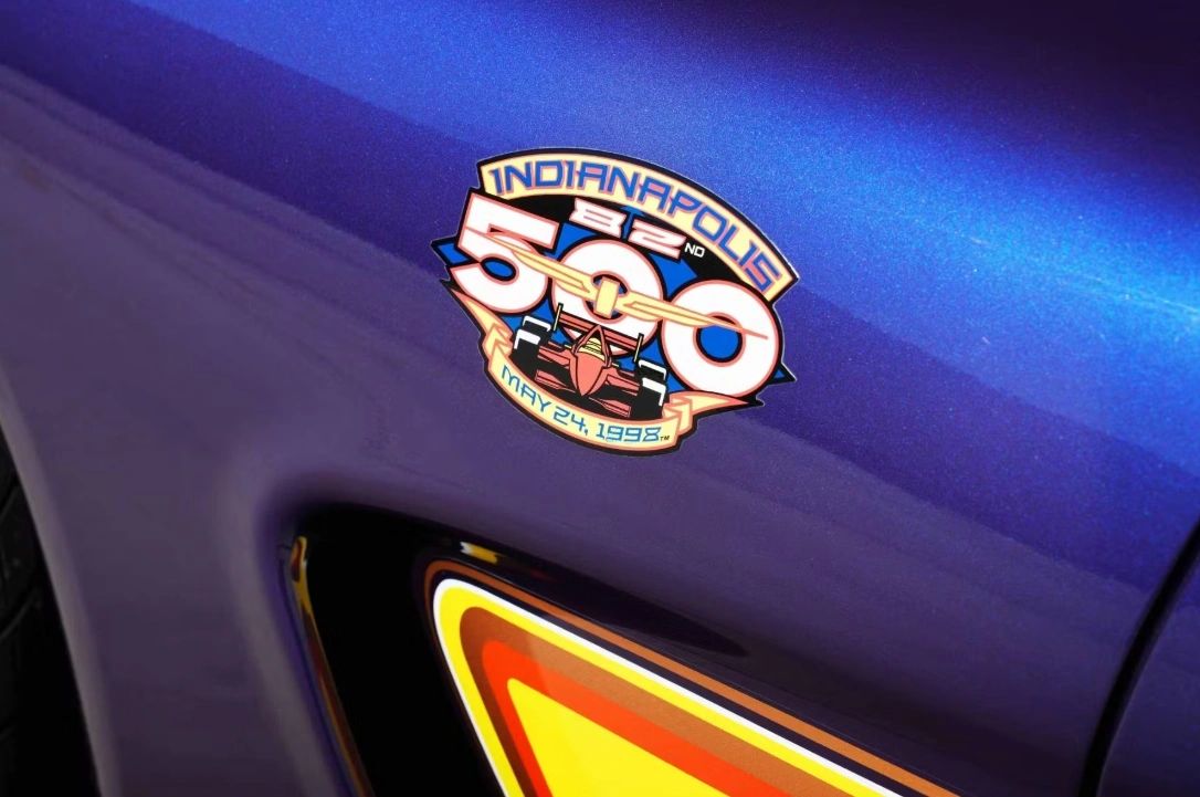 82nd Indianapolis 500 — May 24, 1998. The fender badge on the Radar Blue C5 pace car—stylized “500” wrapped around an IndyCar—serves as a timestamp and a promise: today Corvette leads. The same emblem marked the Z4Z replicas, a small crest linking the street cars to race-day duty and to Parnelli Jones setting the pace.