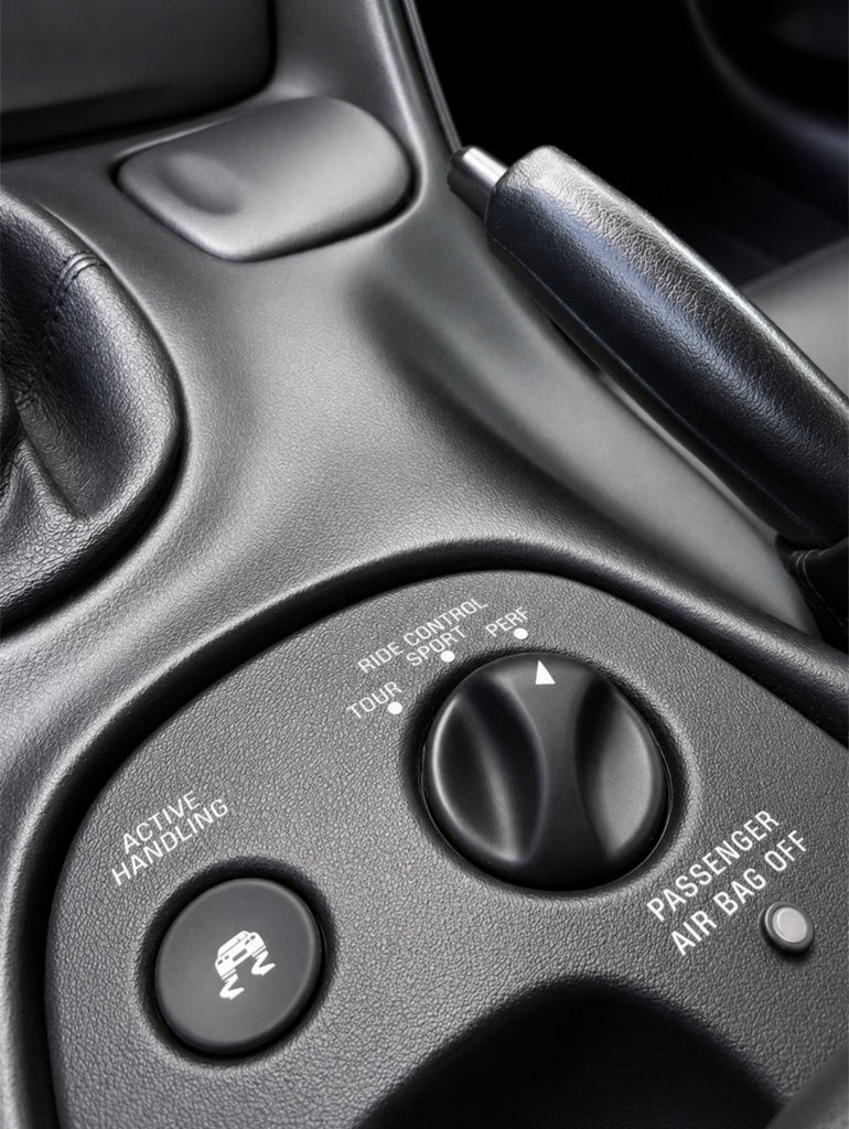 Close-up of the 2001 Corvette Z06 center console showing the Active Handling button, Selective Ride Control dial, and passenger airbag indicator.