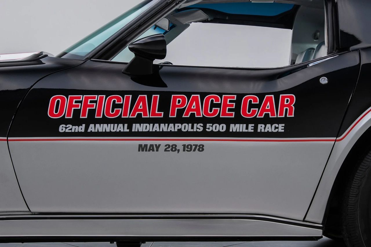 Black over silver does the heavy lifting here, but it’s the razor-thin red pinstripe that makes the car read “pace car” at a glance. The stripe rides the break line like a laser level, sharpening the color transition and tying the nose spoiler, doors, and quarters into one continuous gesture. The door callouts echo the palette—white letters with red shadow on a black field—so the typography becomes part of the livery, not an add-on. It’s a three-color composition that turns the C3’s curves into graphics and the graphics into identity. (Image courtesy of RK Motors) Black over silver does the heavy lifting here, but it’s the razor-thin red pinstripe that makes the car read “pace car” at a glance. The stripe rides the break line like a laser level, sharpening the color transition and tying the nose spoiler, doors, and quarters into one continuous gesture. The door callouts echo the palette—white letters with red shadow on a black field—so the typography becomes part of the livery, not an add-on. It’s a three-color composition that turns the C3’s curves into graphics and the graphics into identity. (Image courtesy of RK Motors)