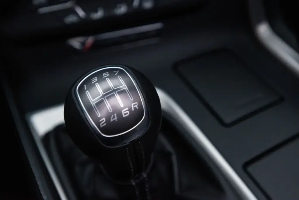 Close-up of the seven-speed manual transmission shifter in a 2015 Chevrolet Corvette, showing the gated 1-through-7 shift pattern and reverse position.