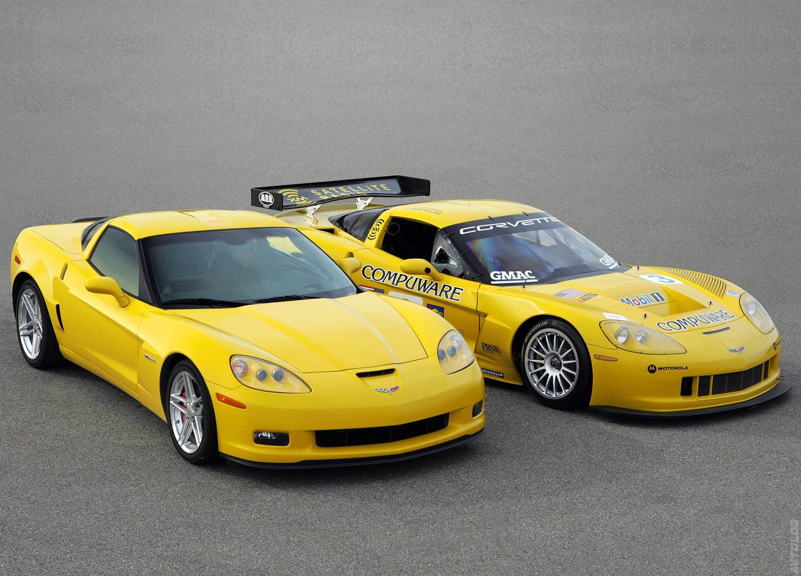 Yellow 2006 Chevrolet Corvette Z06 production coupe positioned alongside a yellow Corvette C6.R GT1 race car wearing Corvette Racing's Compuware and Mobil 1 sponsorship graphics, illustrating the close engineering relationship between Chevrolet's road-going Z06 and its factory endurance racing program.