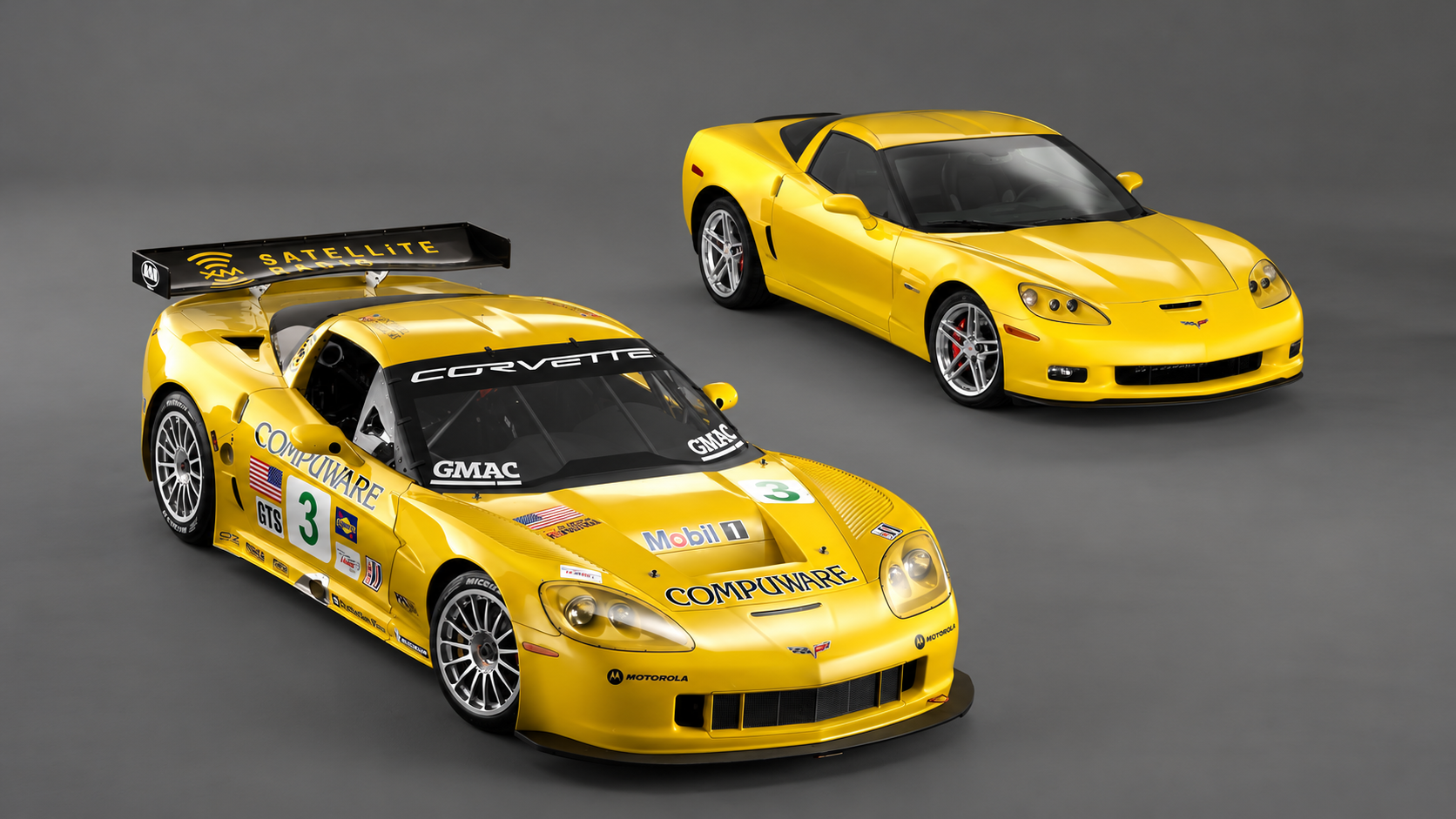 Studio photograph featuring a yellow 2006 Chevrolet Corvette Z06 production coupe positioned behind a yellow No. 3 Corvette C6.R GT1 race car. The C6.R features its distinctive Compuware, Mobil 1, GMAC, and XM Satellite Radio sponsorship graphics, large rear racing wing, aerodynamic bodywork, and competition wheels. Both vehicles are photographed from elevated front three-quarter angles against a neutral gray background, illustrating the close technological relationship between Chevrolet's production and racing programs.